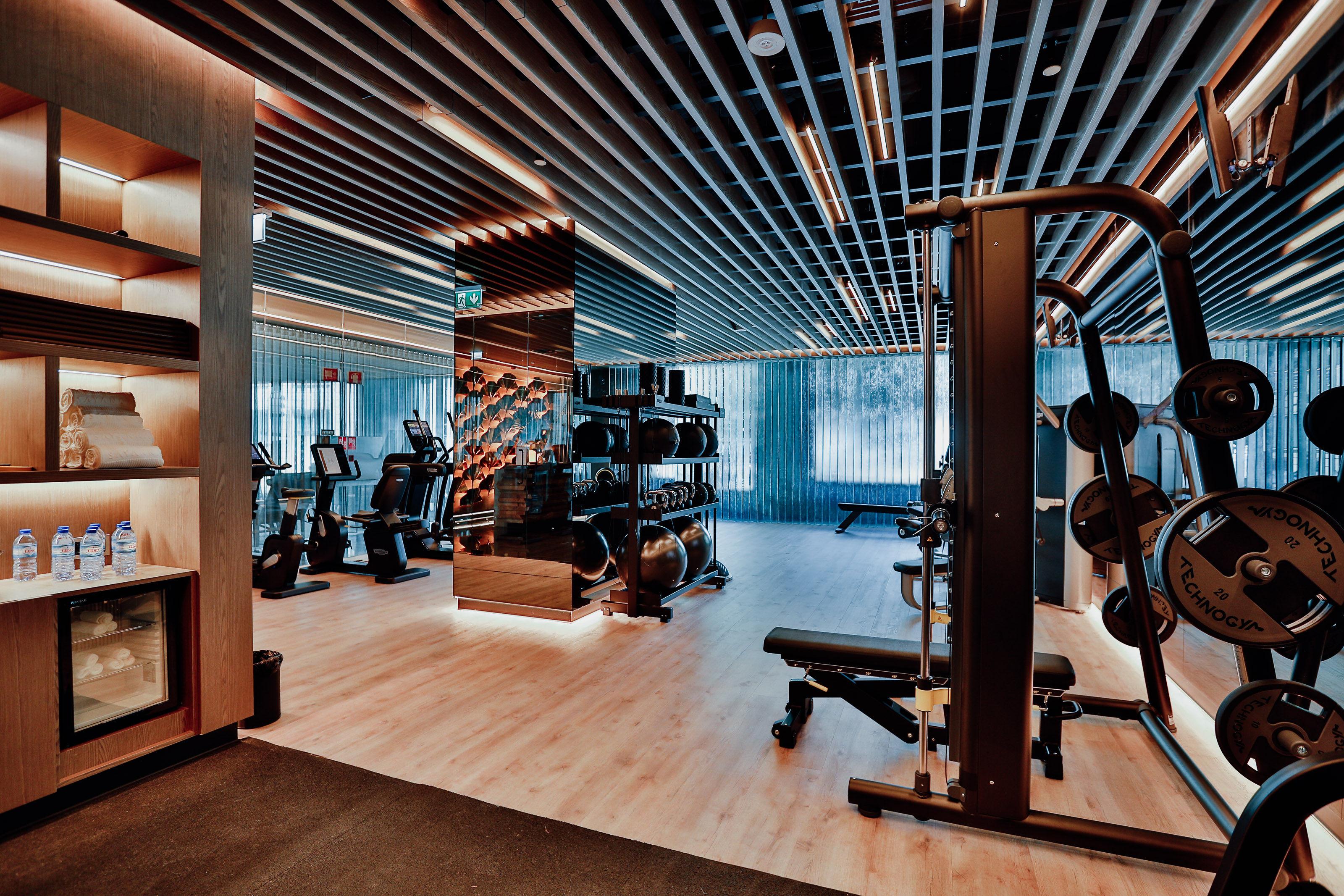 ליסבון Epic Sana Marques Hotel מראה חיצוני תמונה The photo shows a modern gym or fitness center. It features a spacious room with wooden flooring and an illuminated ceiling. There are various exercise machines, including treadmills and weightlifting equipment, arranged neatly throughout the space. 