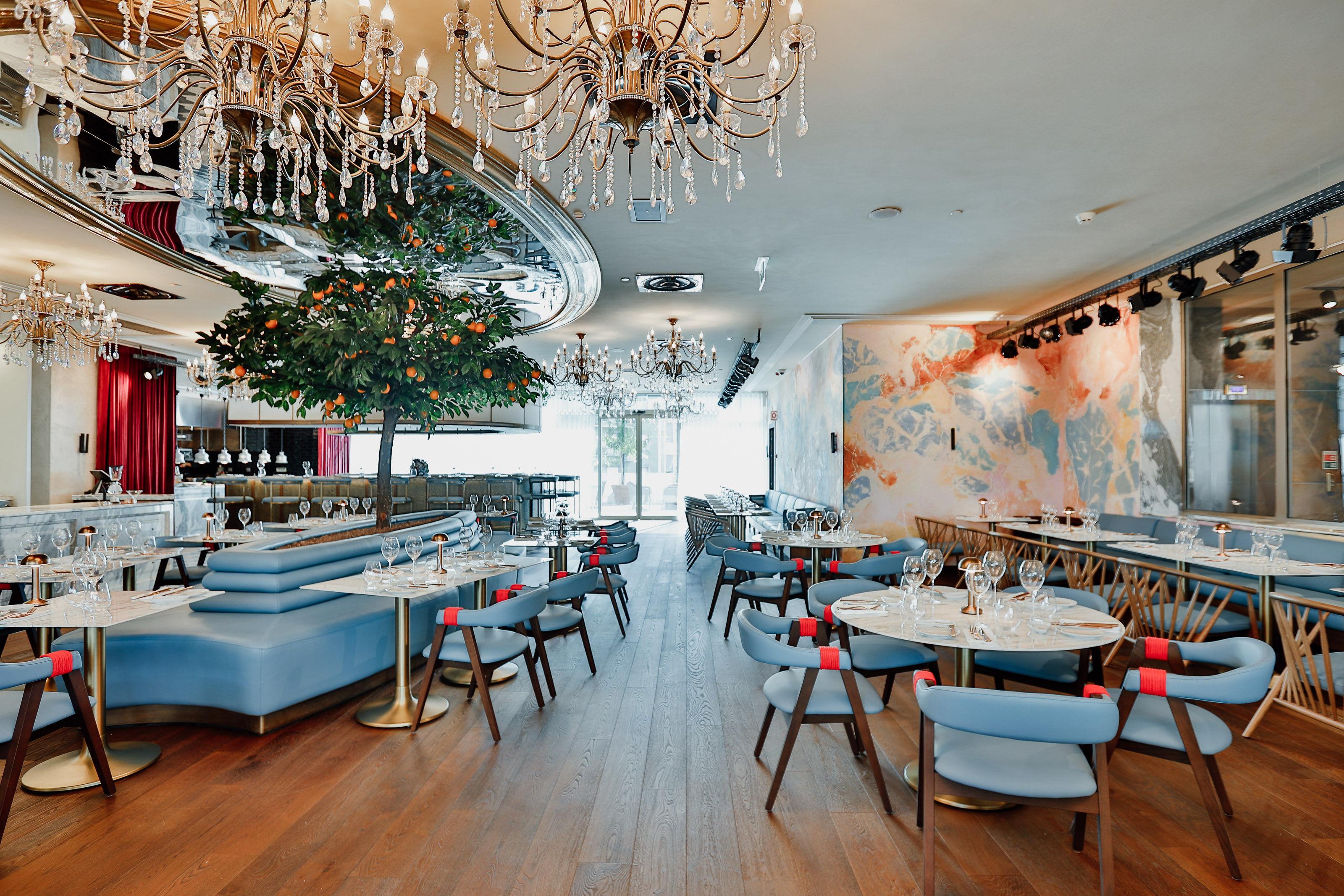 ליסבון Epic Sana Marques Hotel מראה חיצוני תמונה The photo depicts a stylish and modern restaurant interior. There are elegant chandeliers hanging from the ceiling, providing ambient lighting. The flooring is wooden, contributing to a warm atmosphere. 

In the center, there are several dining table